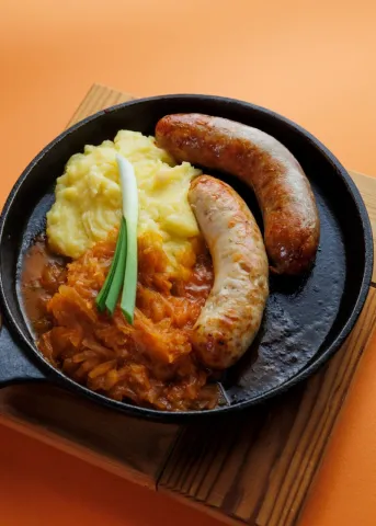 Колбаски с тушеной капустой и картофельным пюре